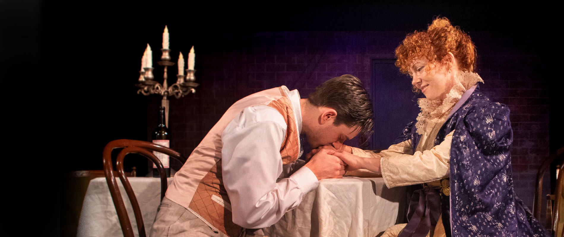 a baker kneeds bread and talks to a customer